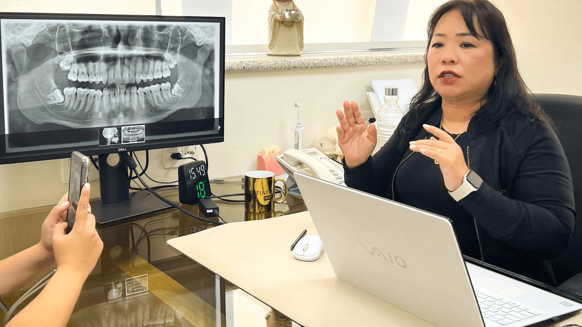 Dra. Claudine analisando radiografia panorâmica para diagnóstico de tratamento de canal.